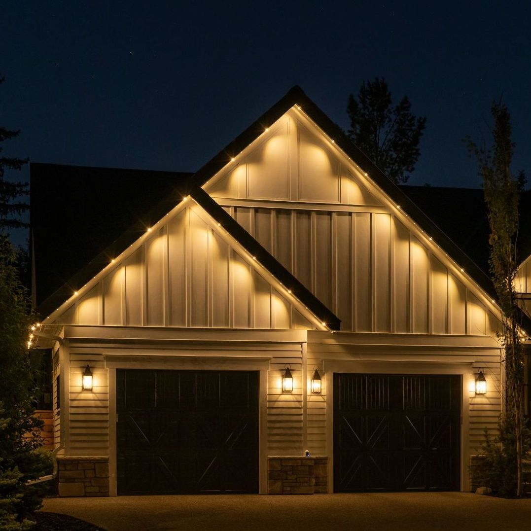 A house with two garage doors is lit up at night