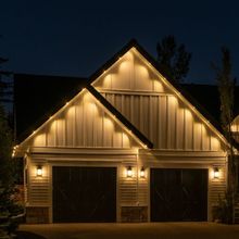 A house with two garage doors is lit up at night