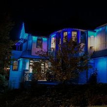 A house is lit up with blue lights at night.