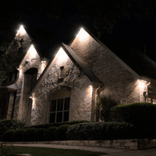 A large brick house is lit up at night