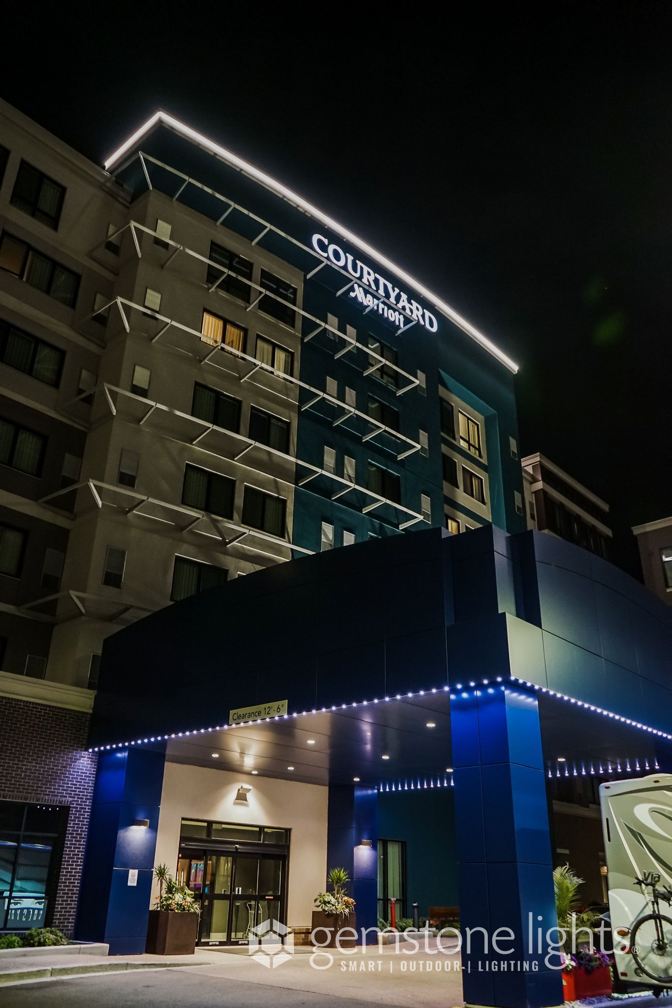 A large building with a blue awning is lit up at night.