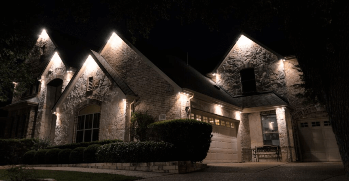 A large brick house is lit up at night.