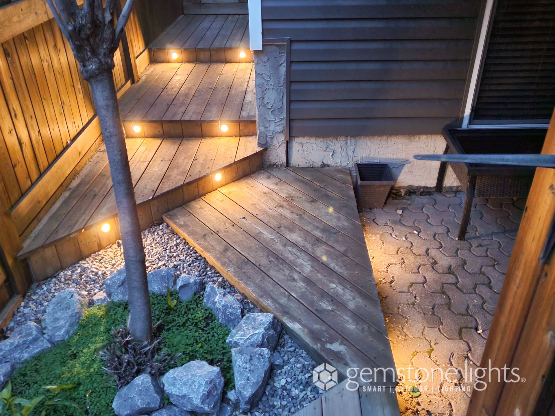 A wooden deck with stairs and lights on it