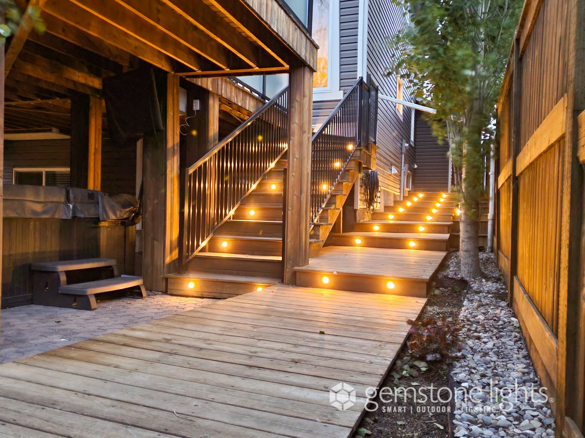 A wooden deck with stairs that are lit up at night