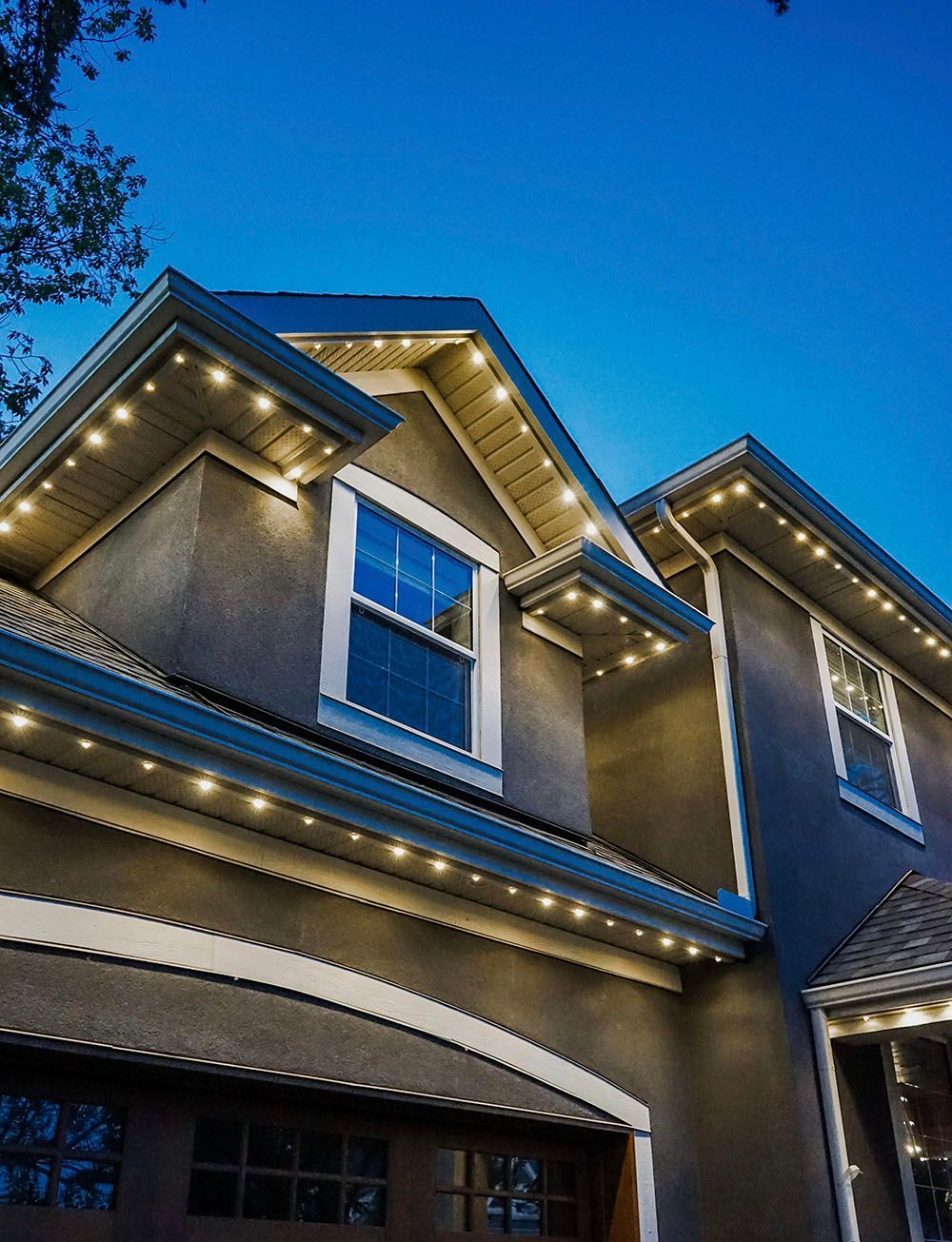 A large house with lights on the roof at night