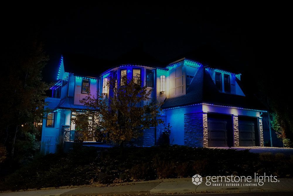 A large house is lit up with blue lights at night.