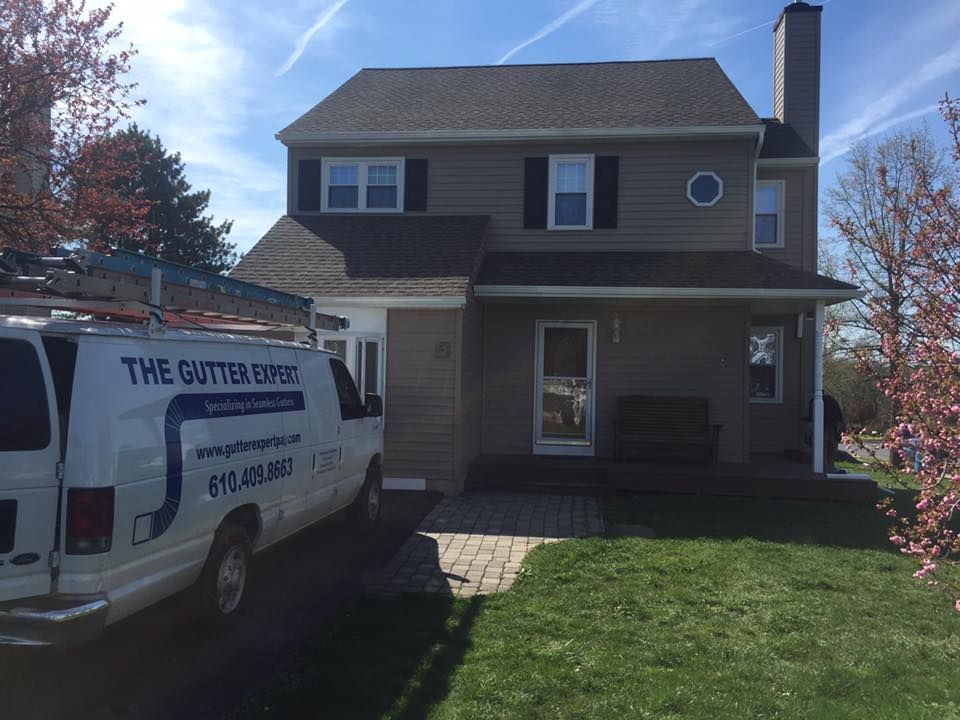 A white van is parked in front of a house.