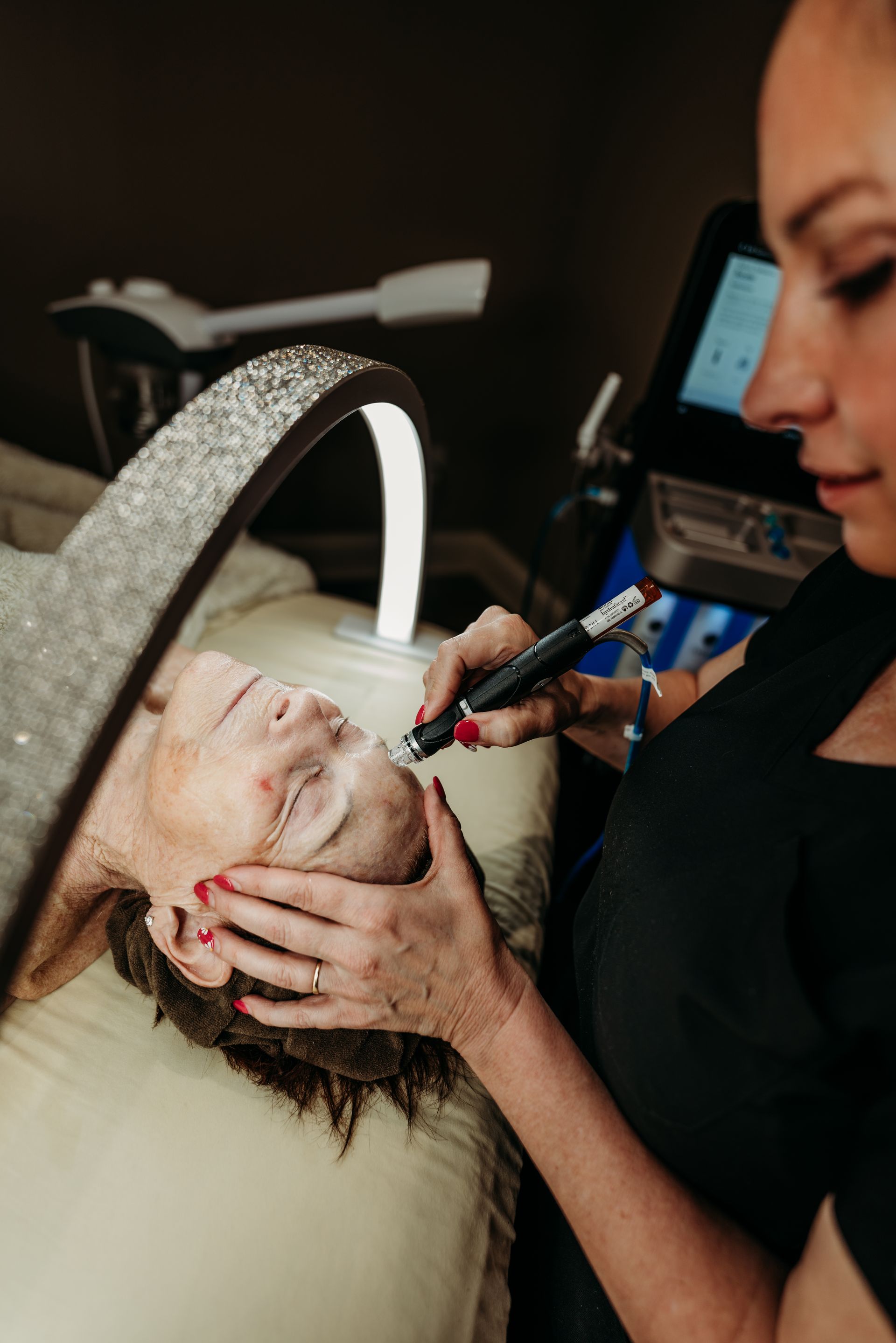 A woman is getting a facial treatment at a beauty salon.