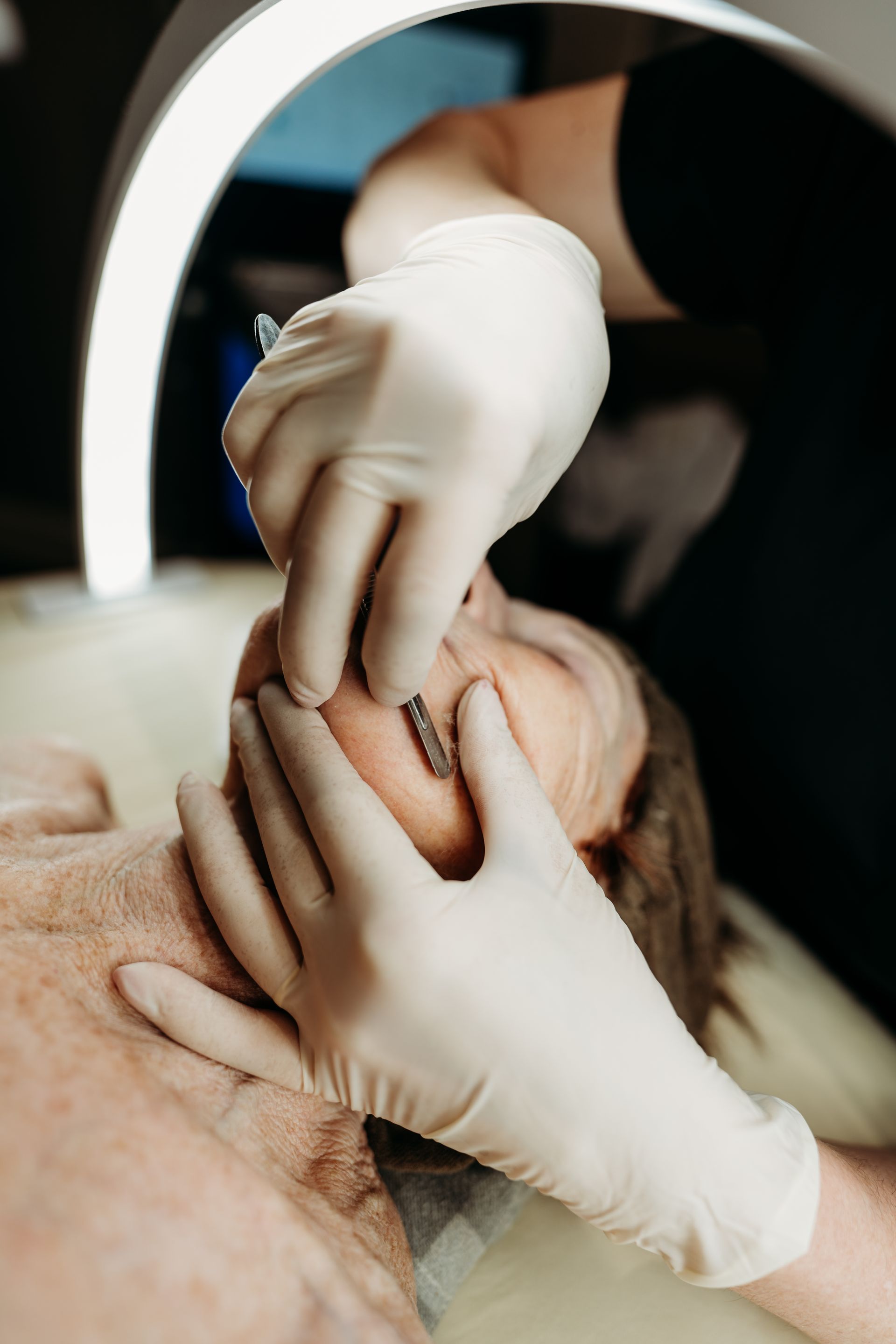 A woman is getting a facial treatment at a beauty salon.