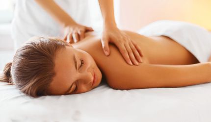 A person getting waxed on legs and eyebrows.  Gloved hands applying wax to skin.