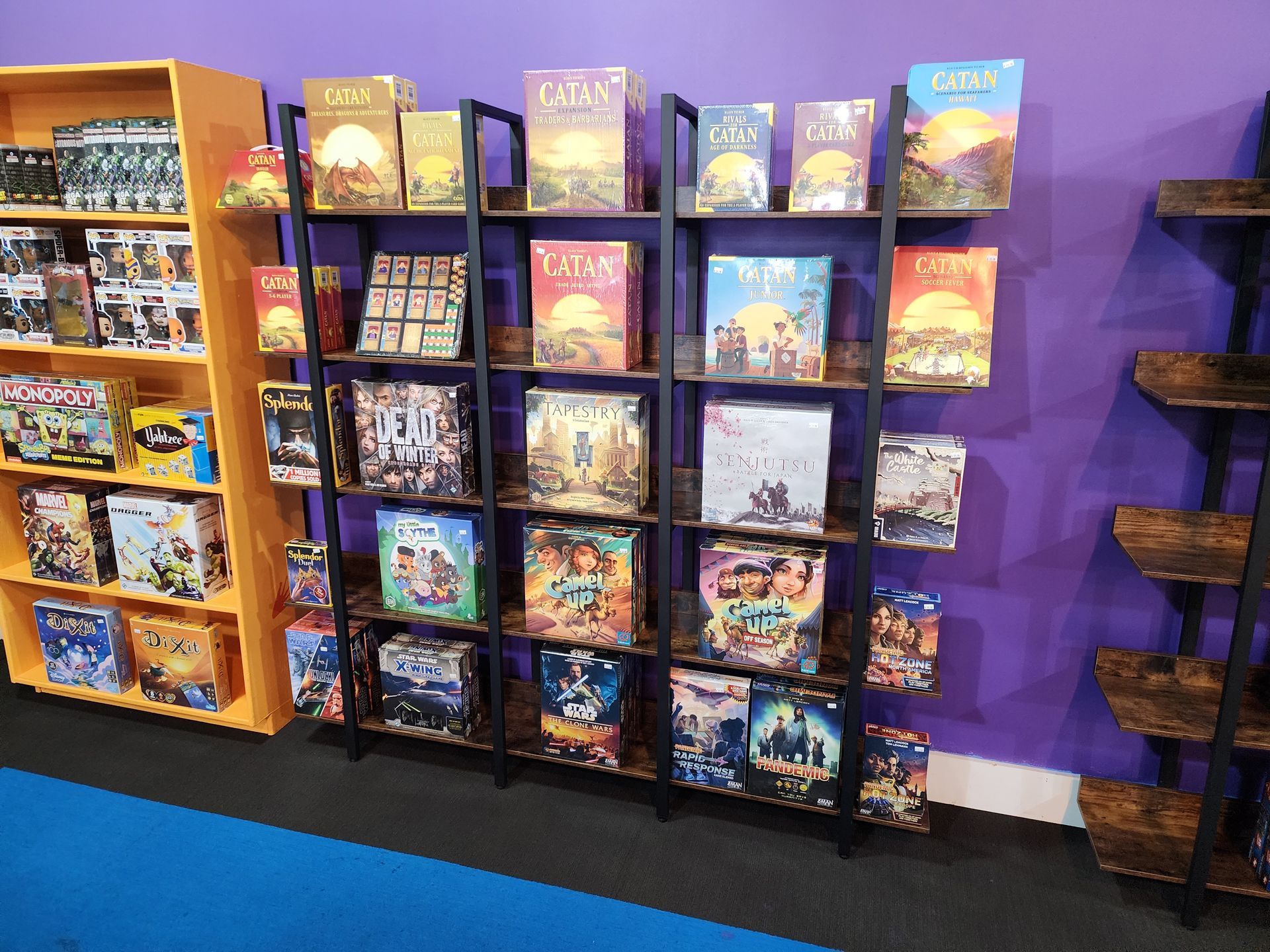 Shelf full of board games including Catan