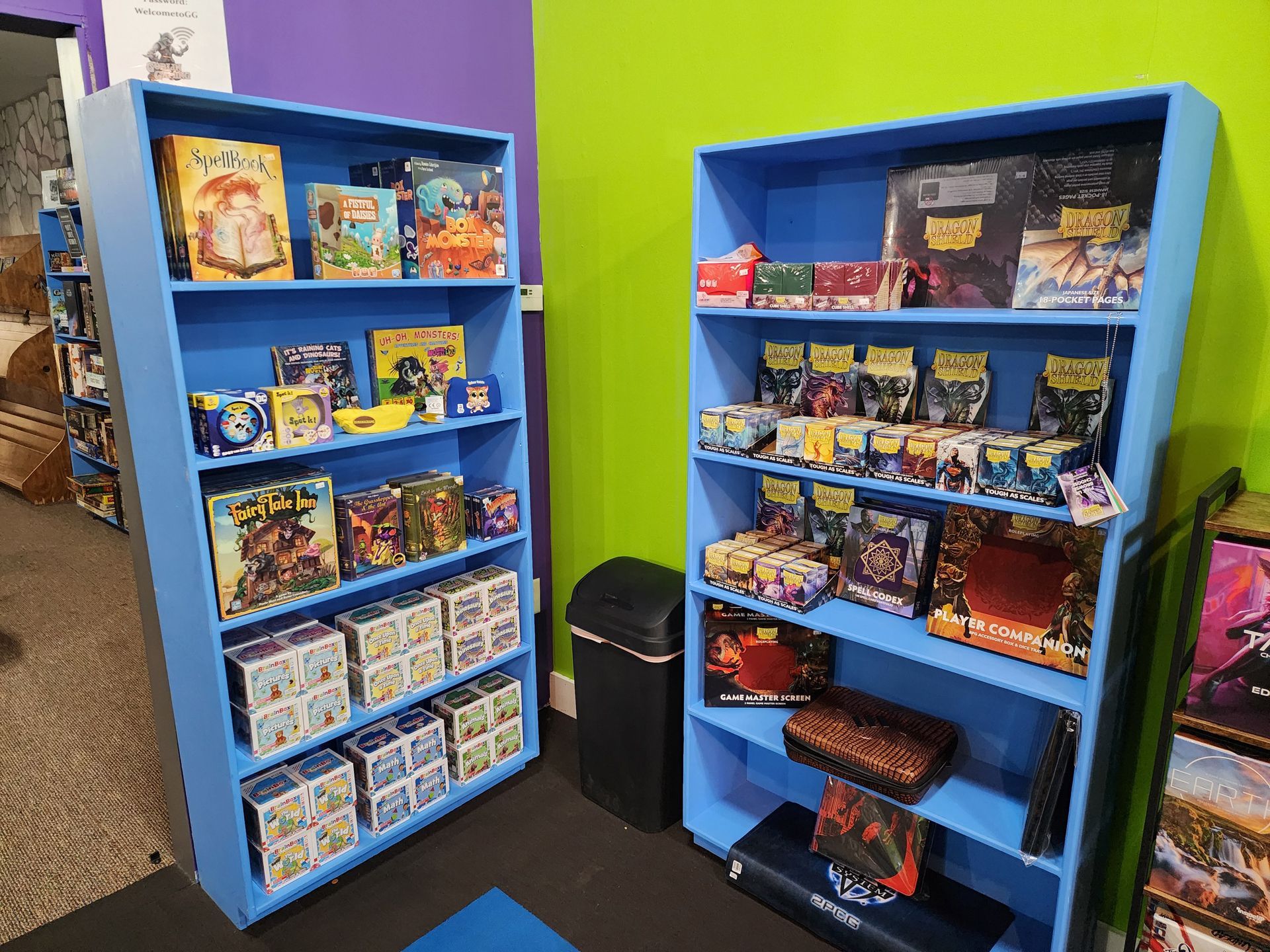 Two blue shelves filled with lots of board games in a room