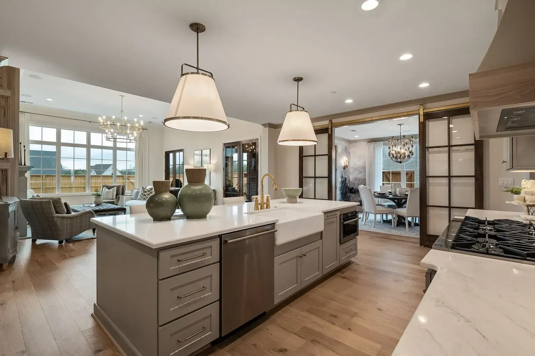 Spacious kitchen with island, pendant lights, and a view into the living room.