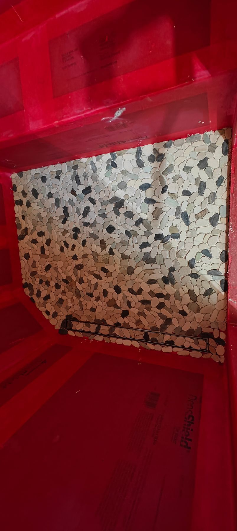 Red plastic pet crate with a speckled gray cushion inside.