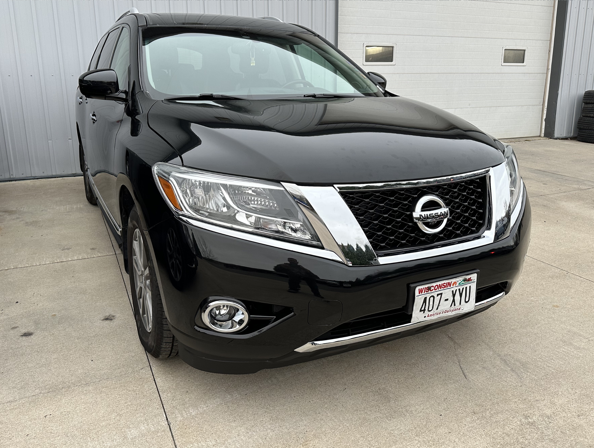 Black Nissan Pathfinder SUV parked outside a building.