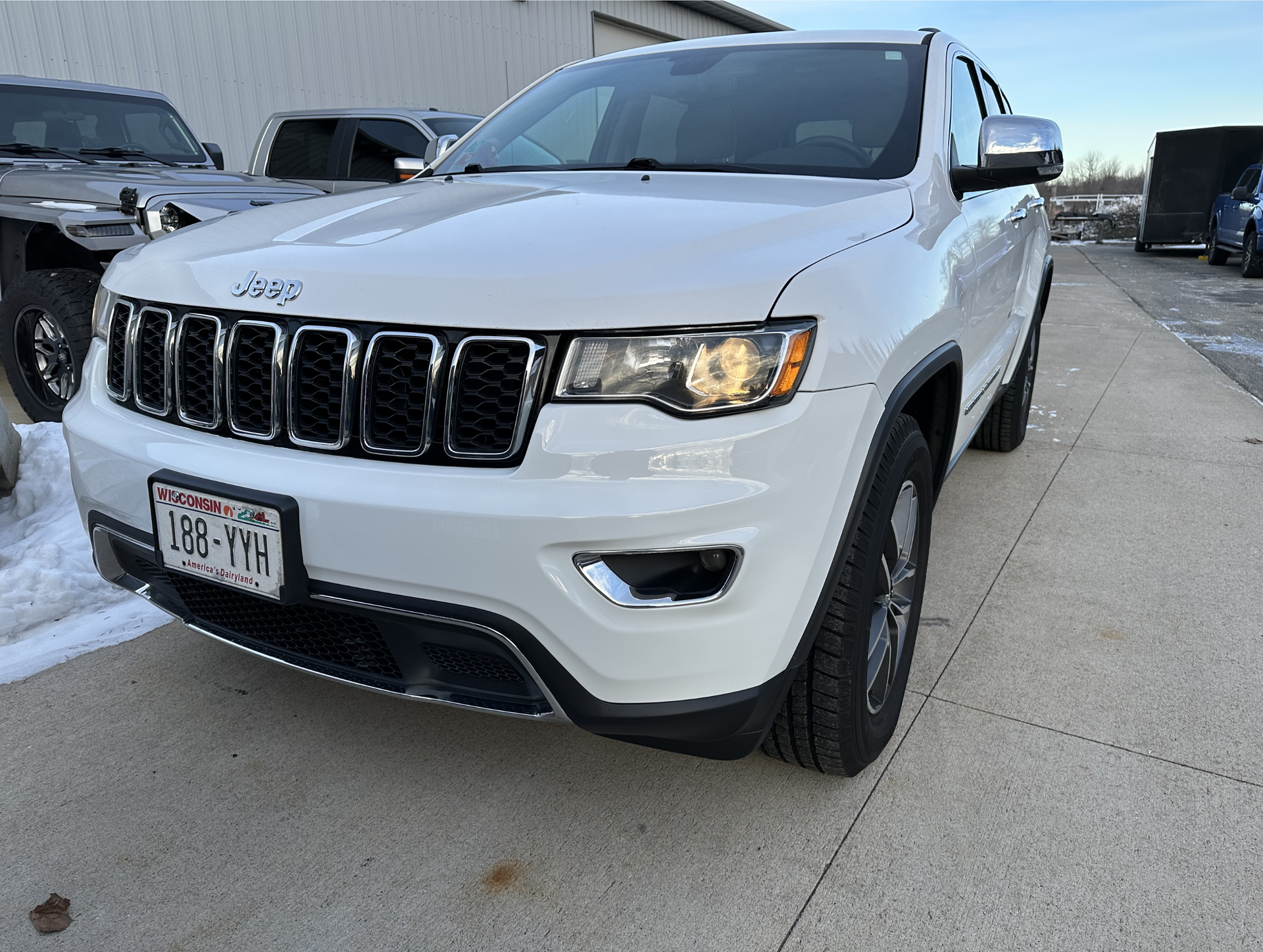 White Jeep Grand Cherokee parked outdoors, Minnesota license plate, front view.