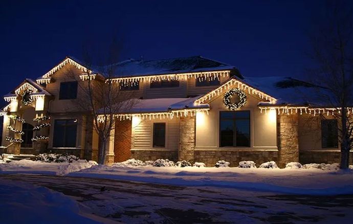 A large house is lit up with Christmas lights at night