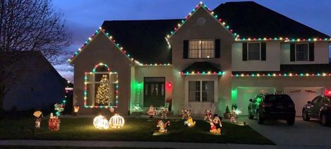 A large house is decorated with christmas lights and decorations.