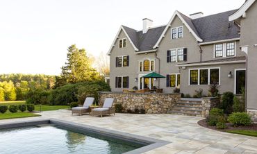 A large house with a swimming pool in front of it