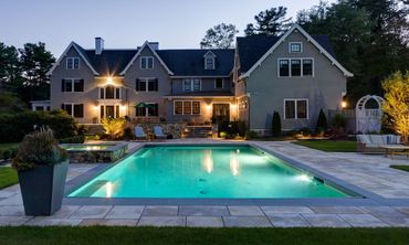 A large house with a large swimming pool in front of it