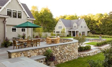 A large house with a patio and umbrellas in front of it