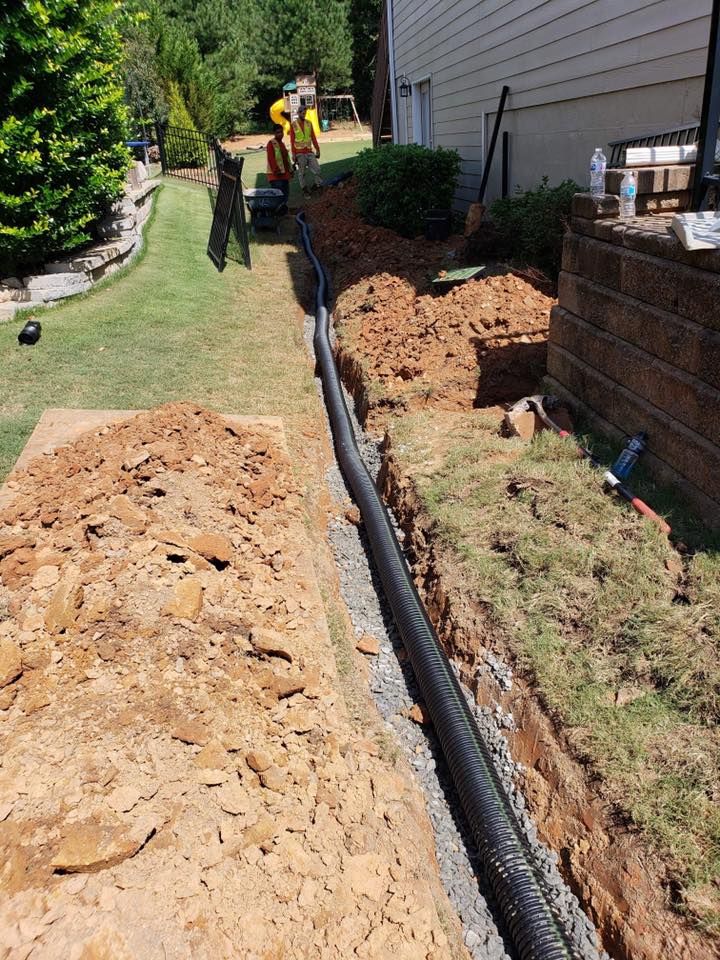A drainage system is being installed on the side of a house.