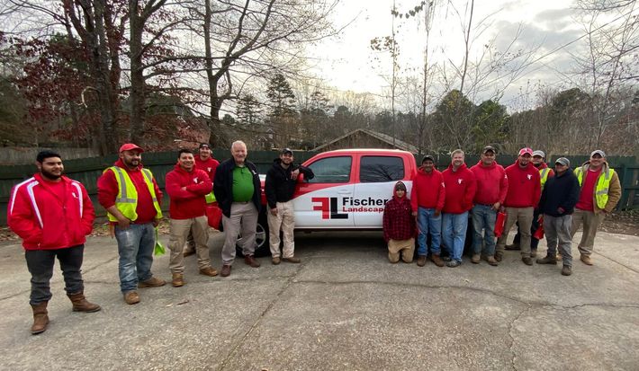 A group of men are posing for a picture in front of a truck.