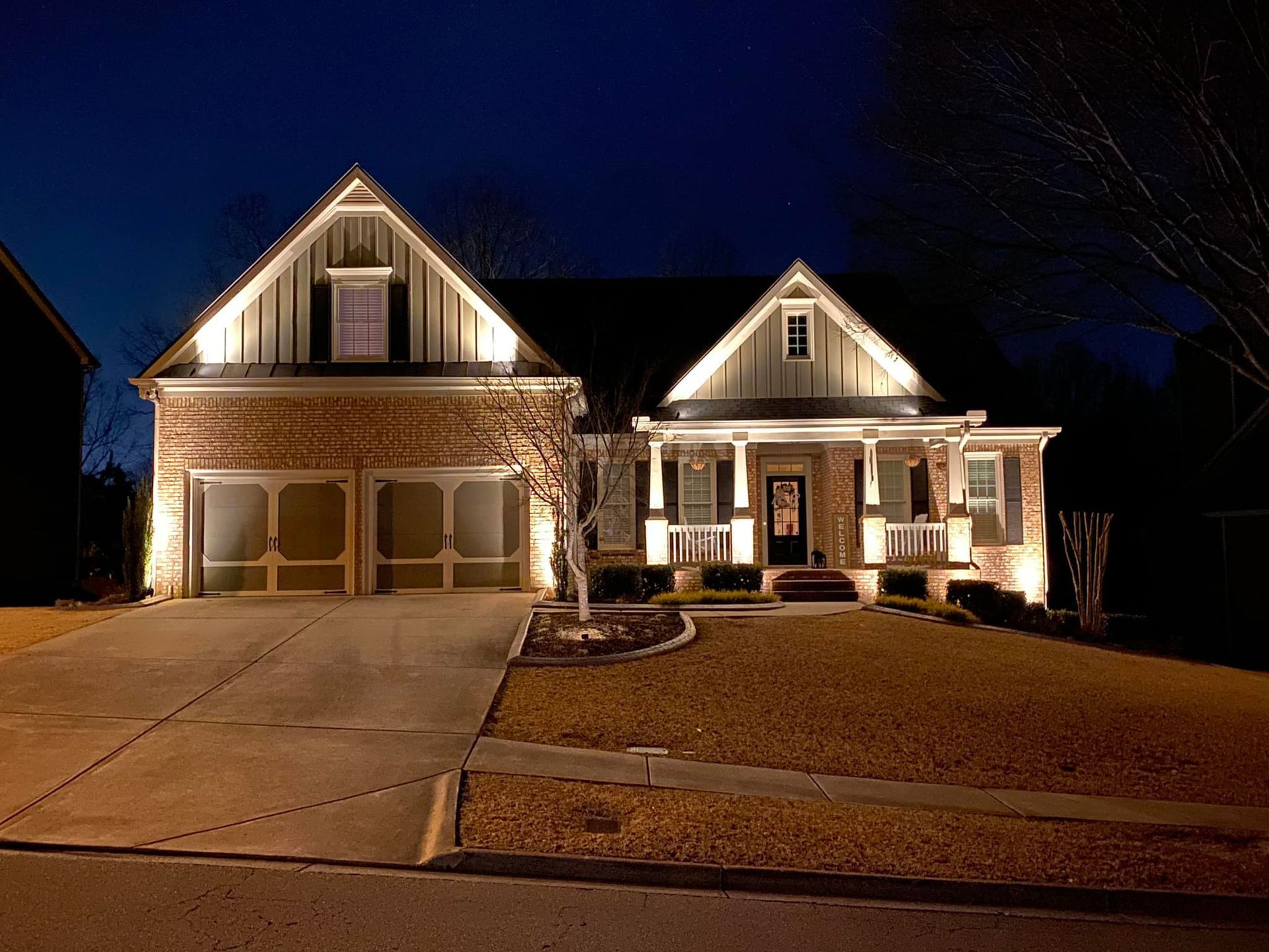The front of a house is lit up at night.