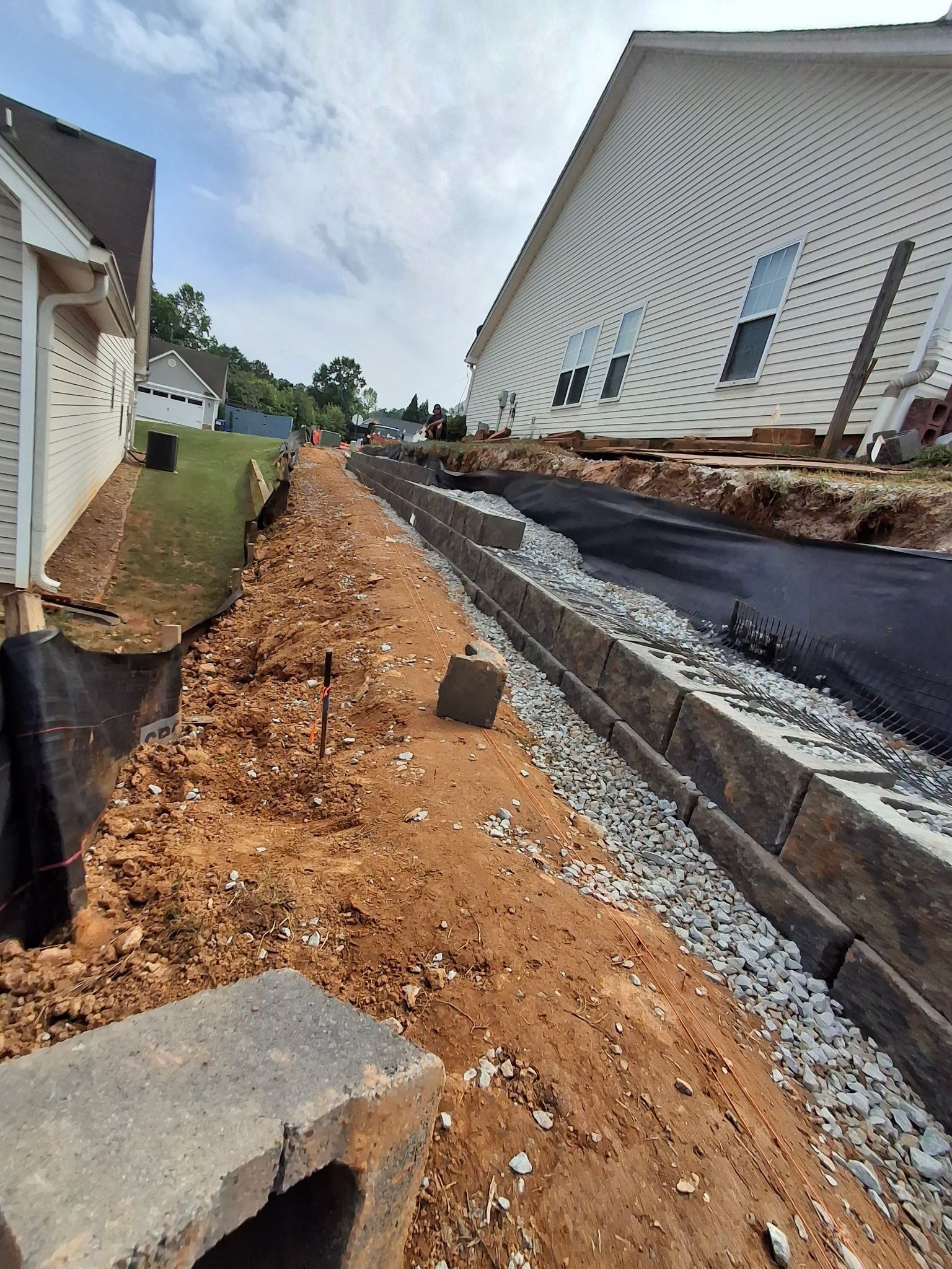 A house is being built next to a dirt road.