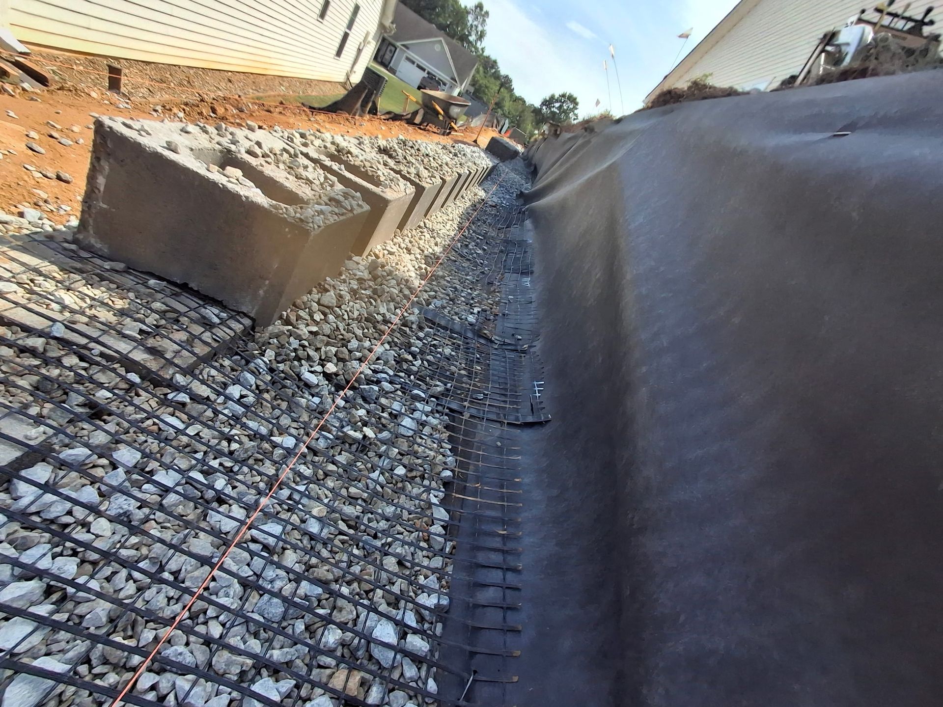 A drainage system is being installed on the side of a house.