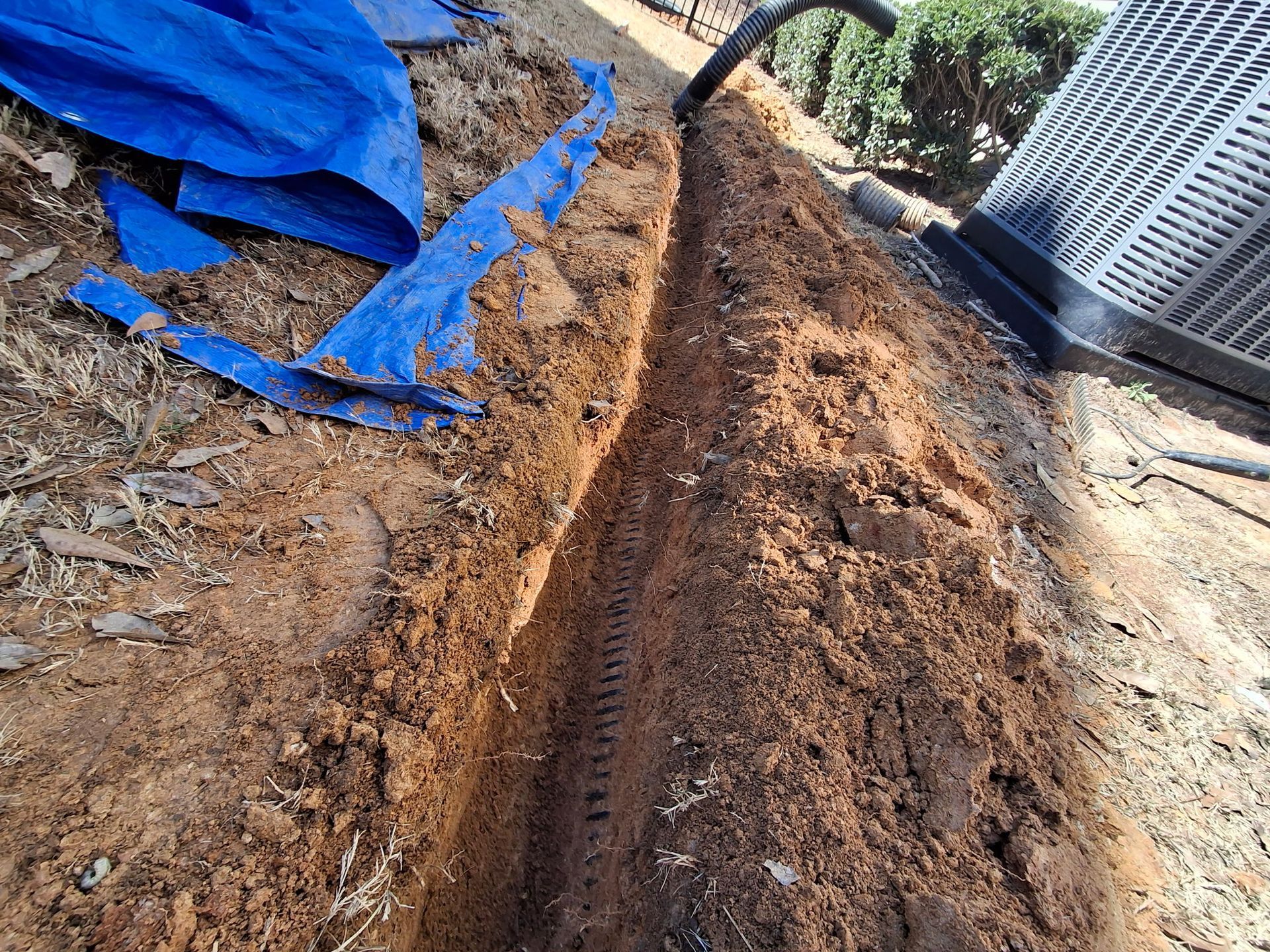 A blue tarp is laying on top of a pile of dirt.
