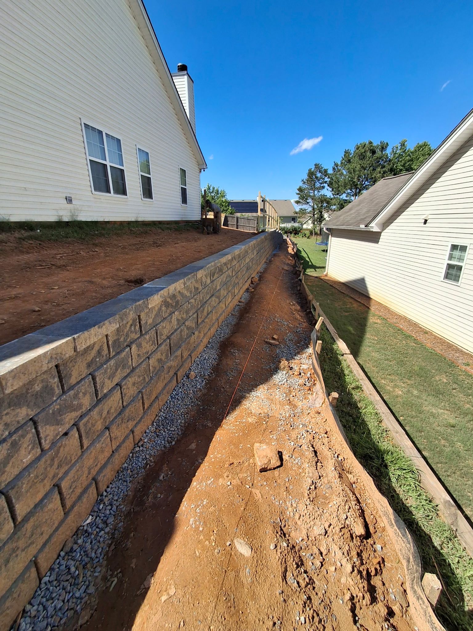 A brick wall is being built in front of a house.