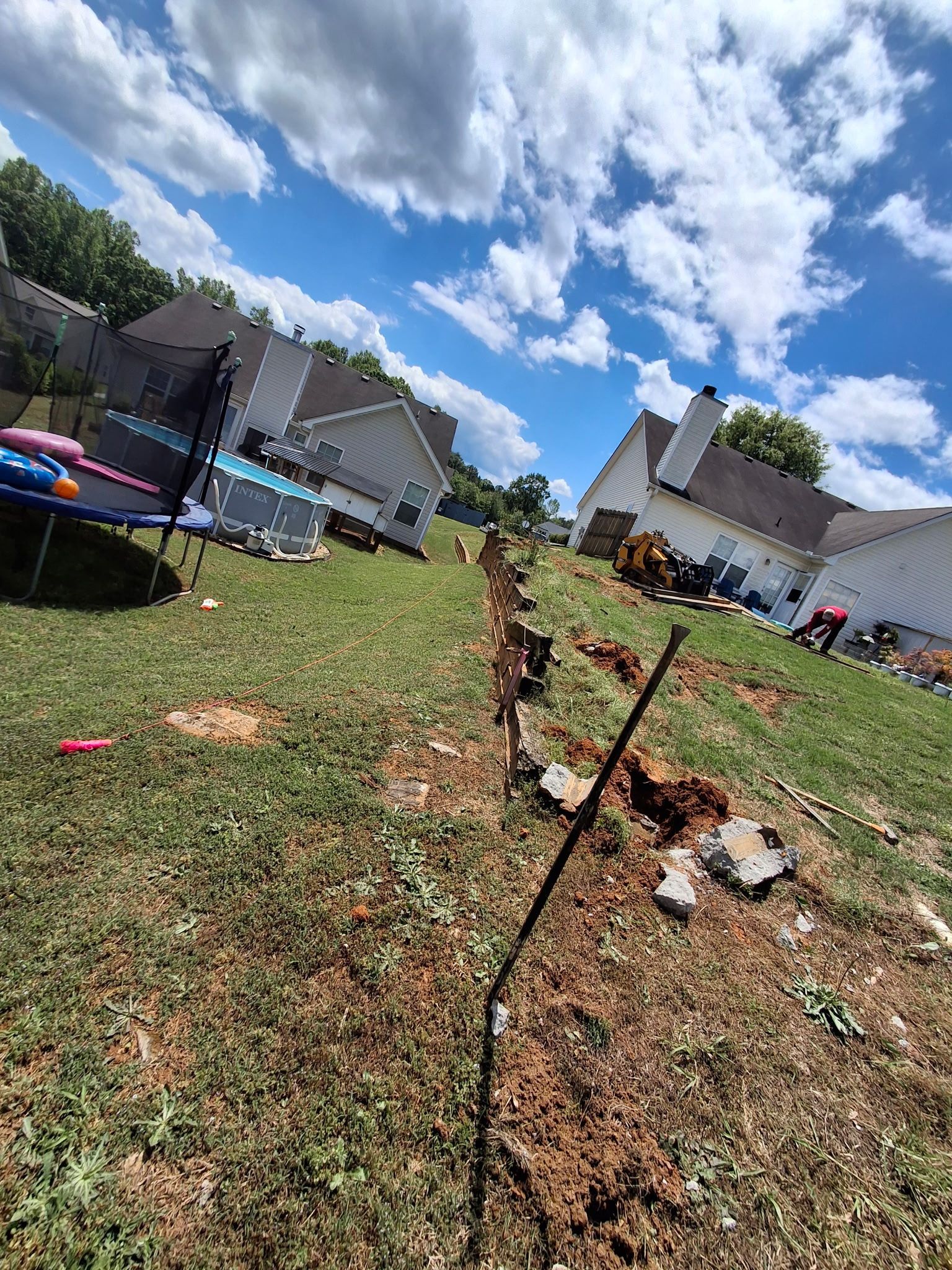 A trampoline is sitting in the middle of a lush green field.