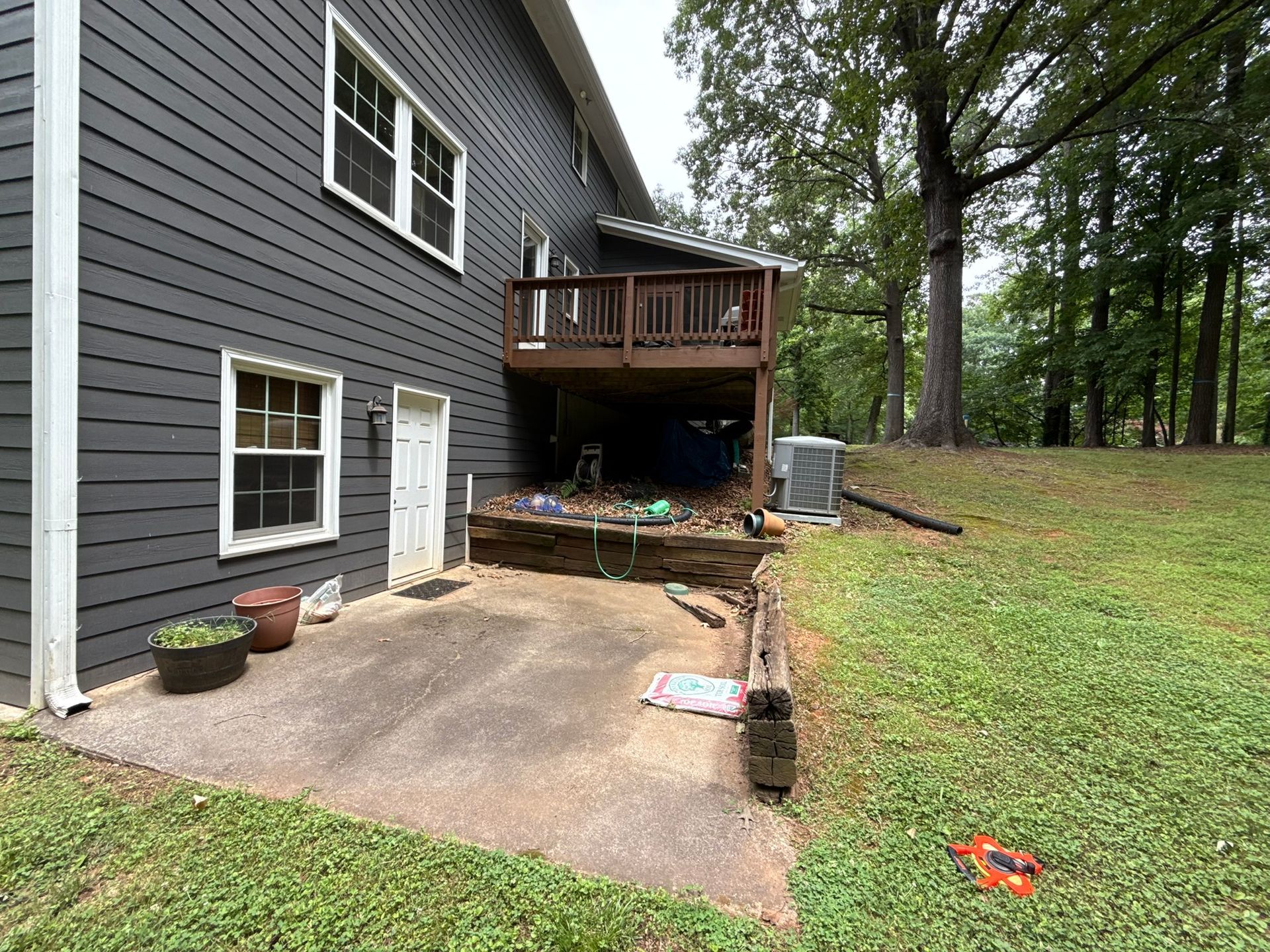 The backyard of a house with a deck and a driveway.