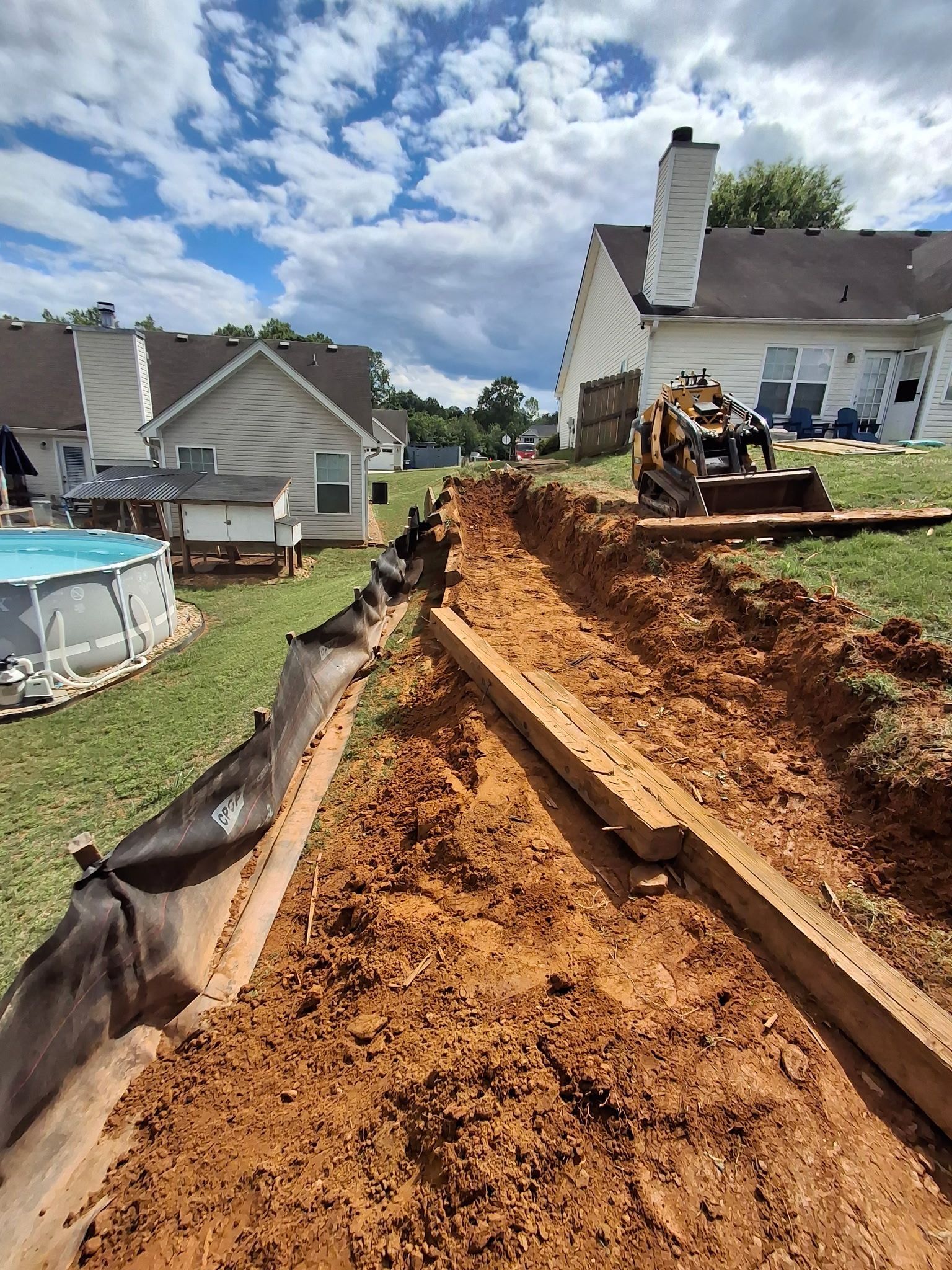 A pool is being built in the backyard of a house.