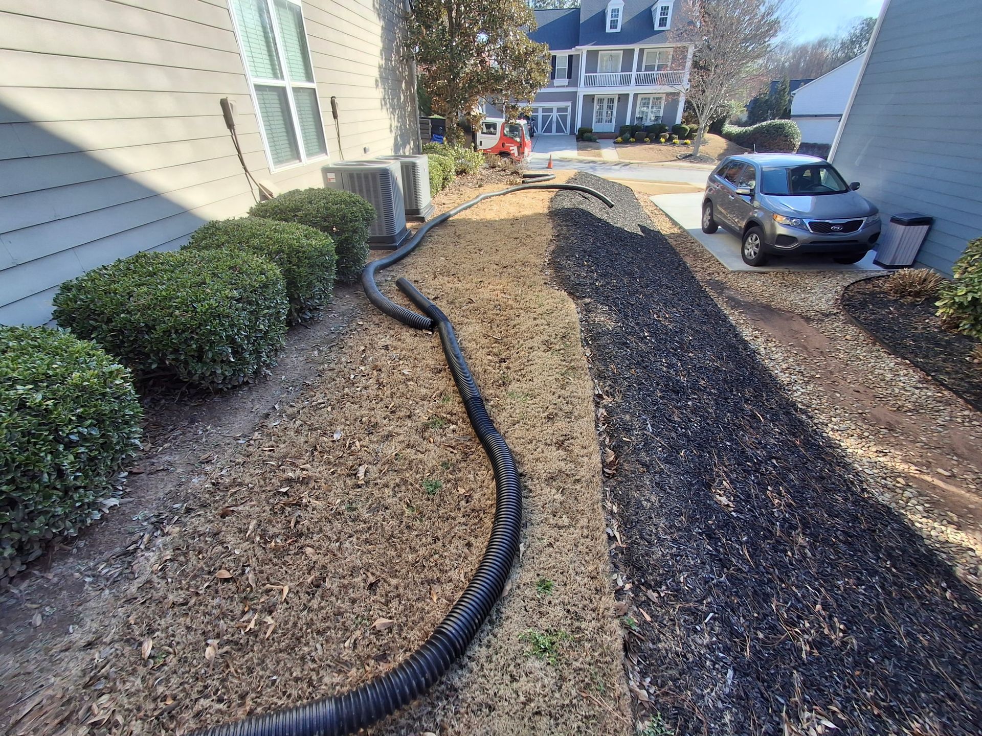 A car is parked in a driveway next to a house.