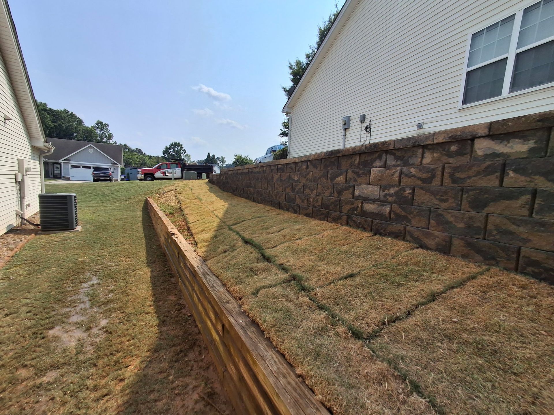 There is a brick wall in the backyard of a house.