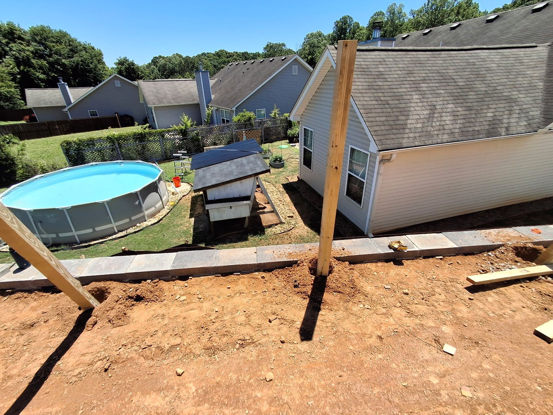 A swimming pool is being built in the backyard of a house.