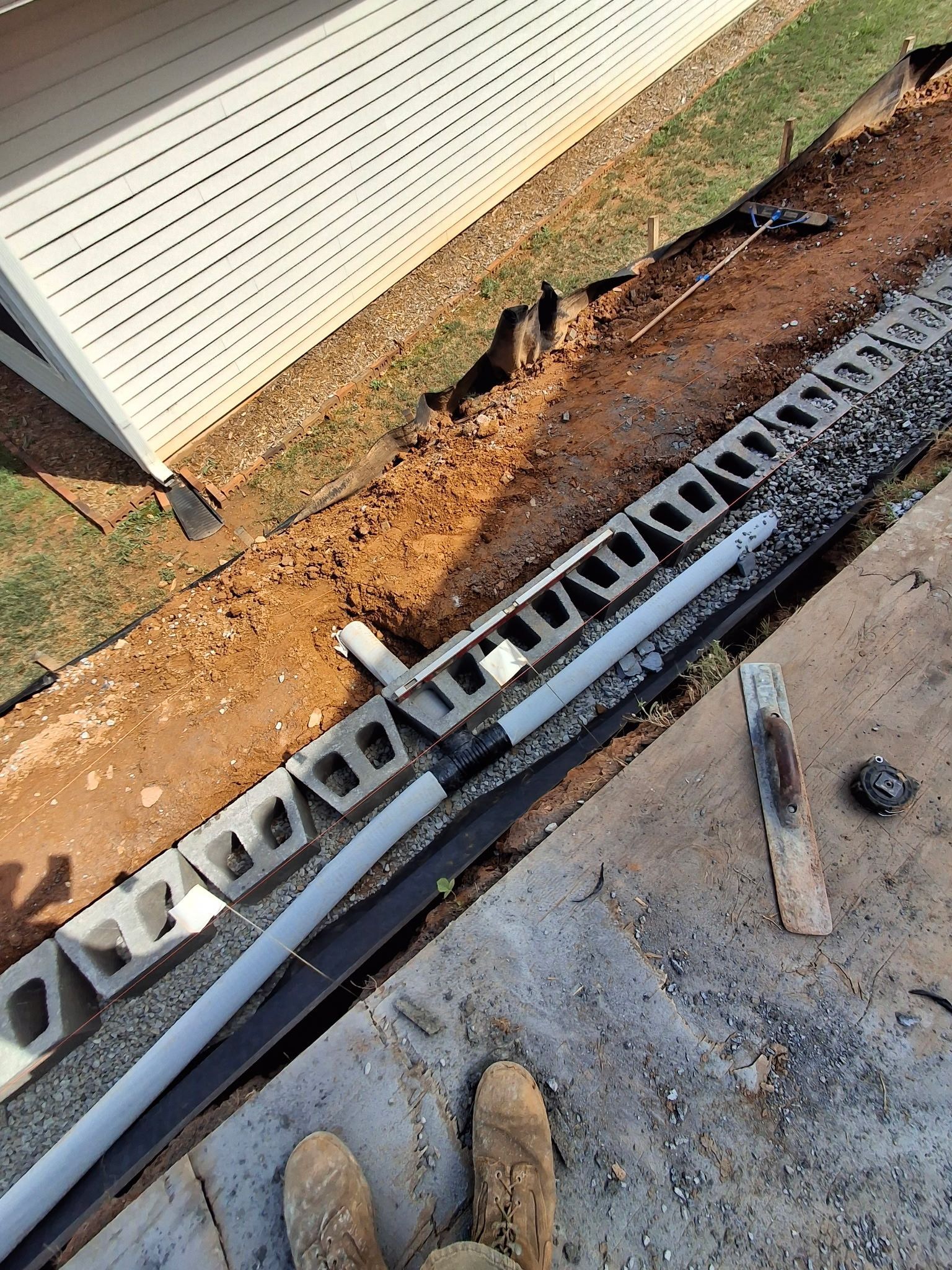 A ladder is laying on the ground next to a house.
