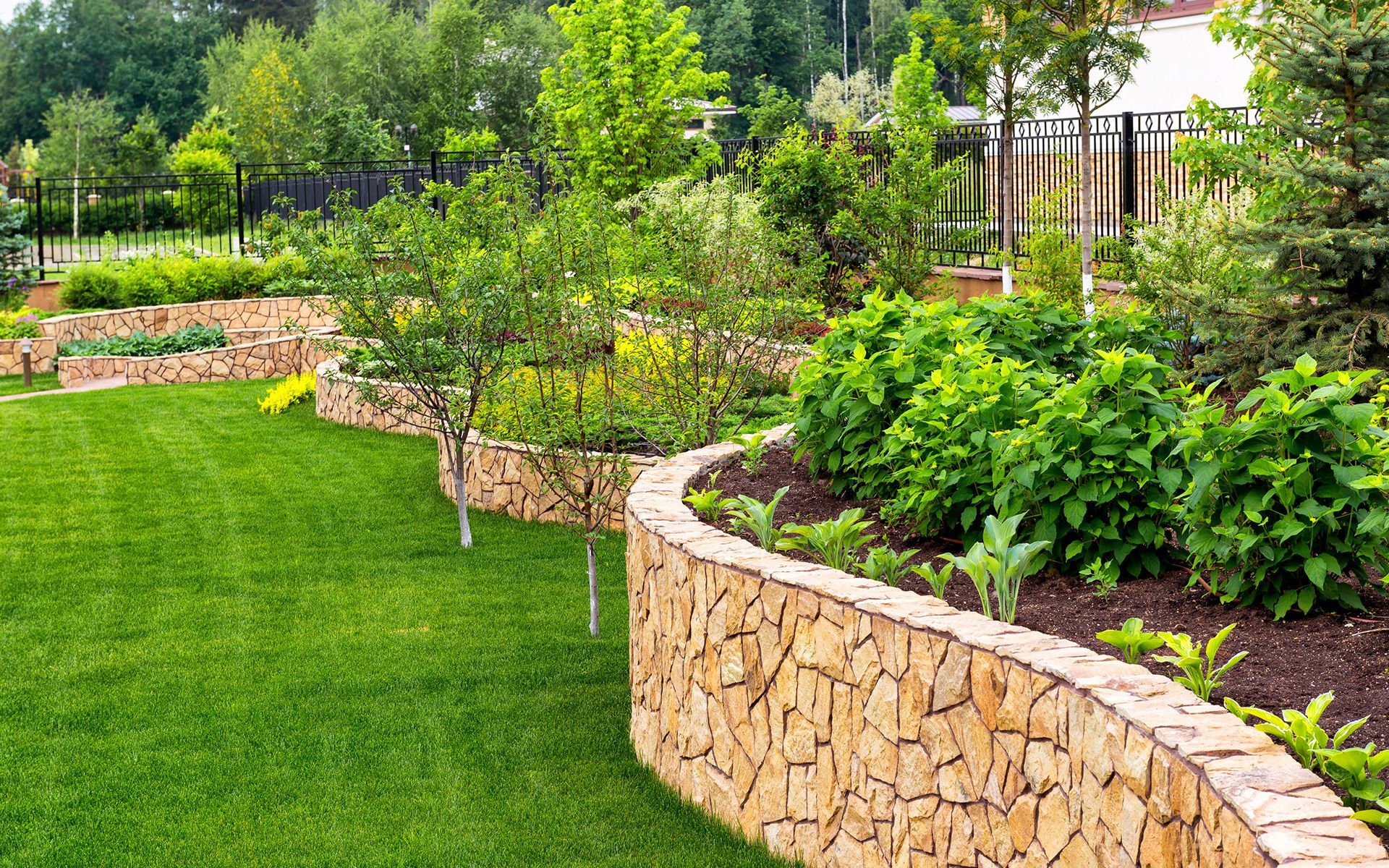 There is a stone wall in the middle of the garden.