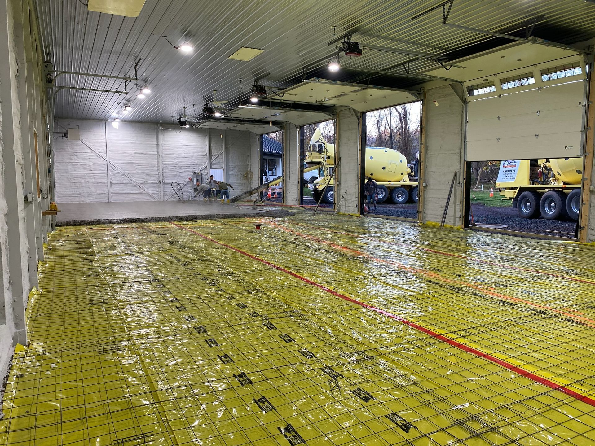 a large garage with a yellow tarp on the floor and a truck in the background