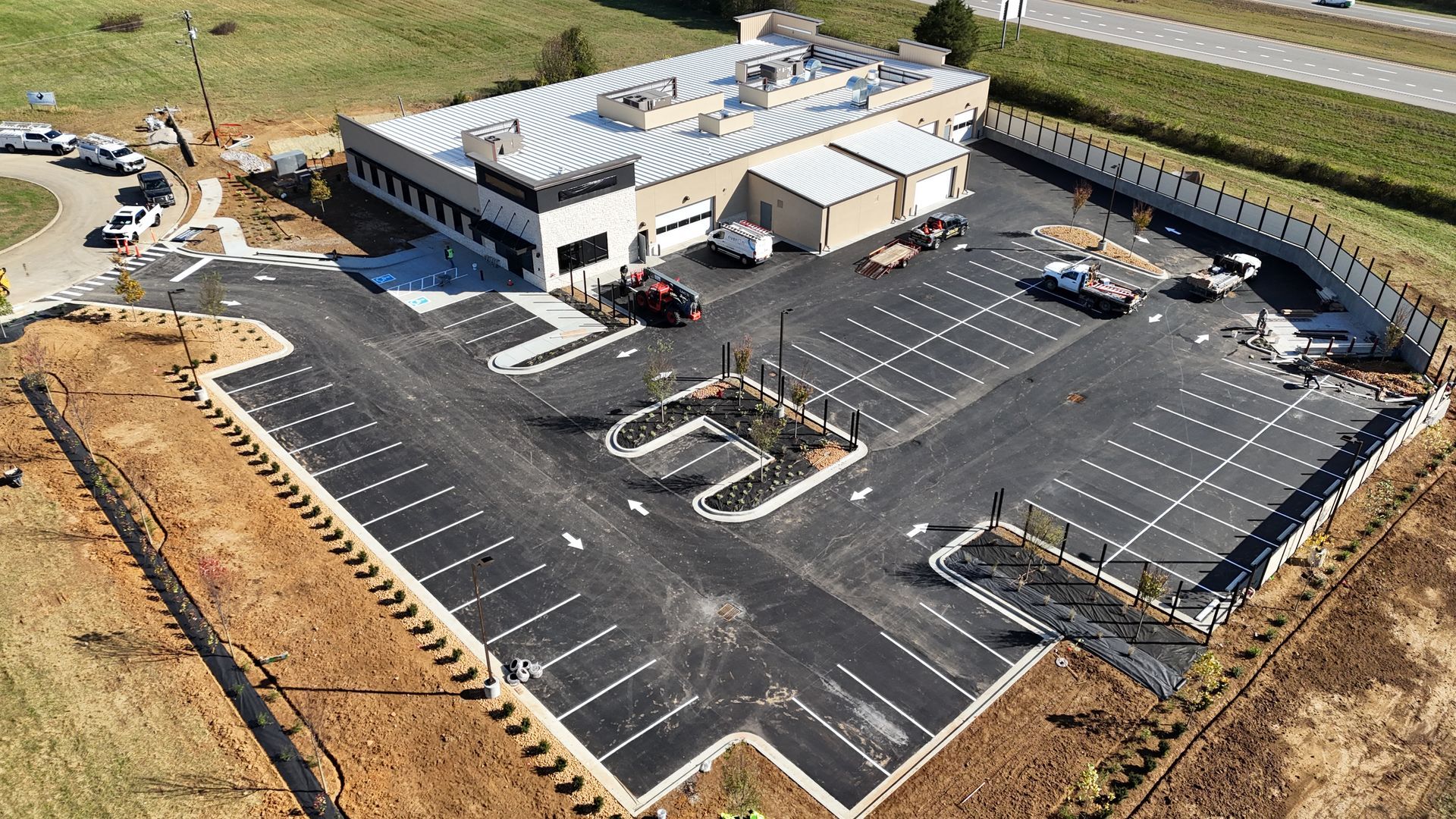 An aerial view of a parking lot with a building in the background.