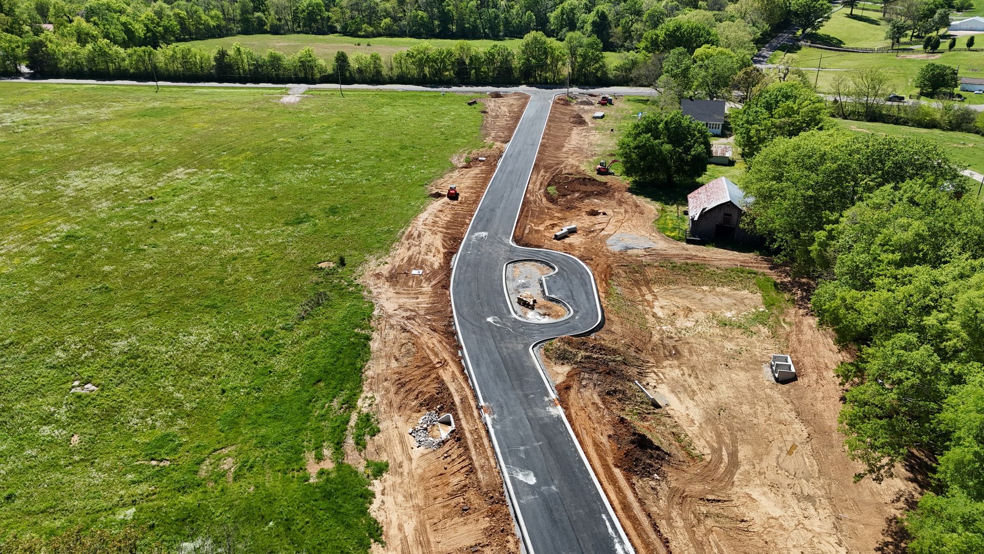 An aerial view of a road being built in a field.