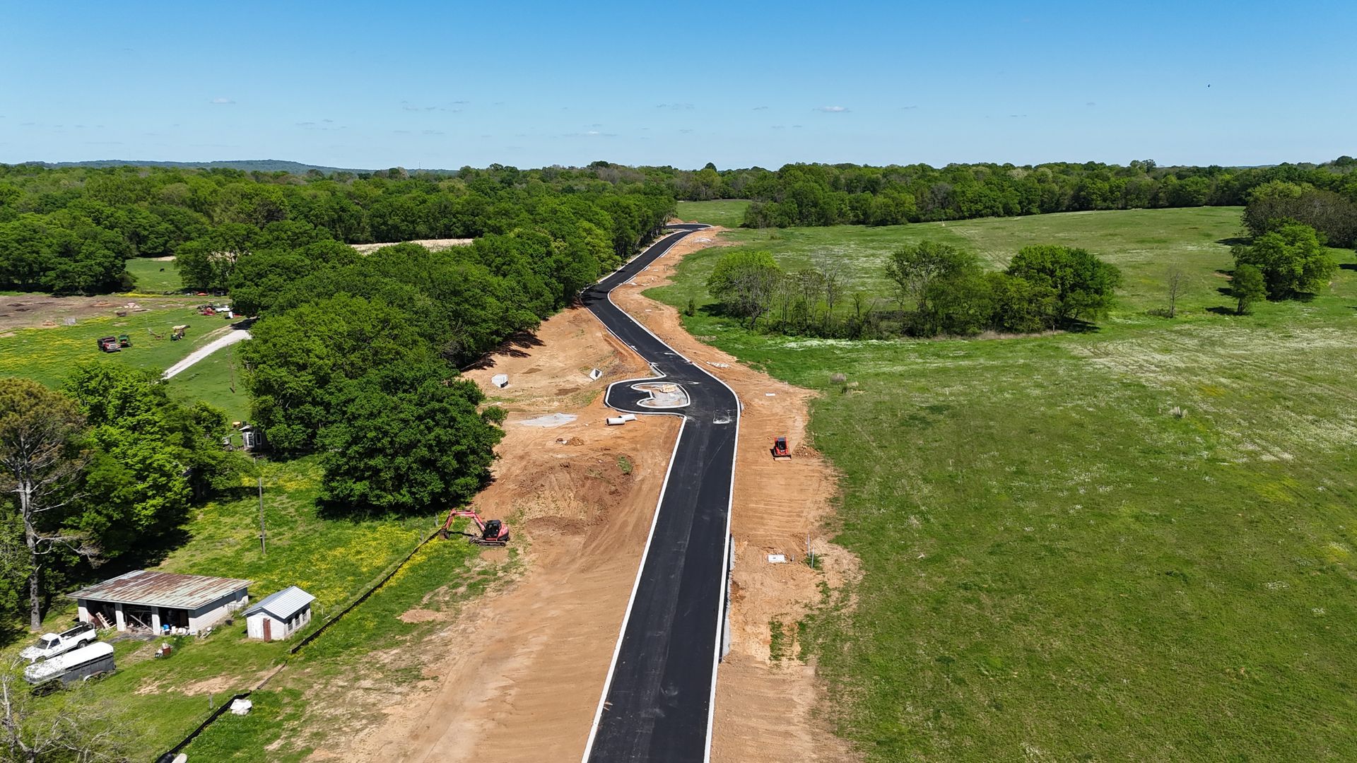 An aerial view of a road going through a field.