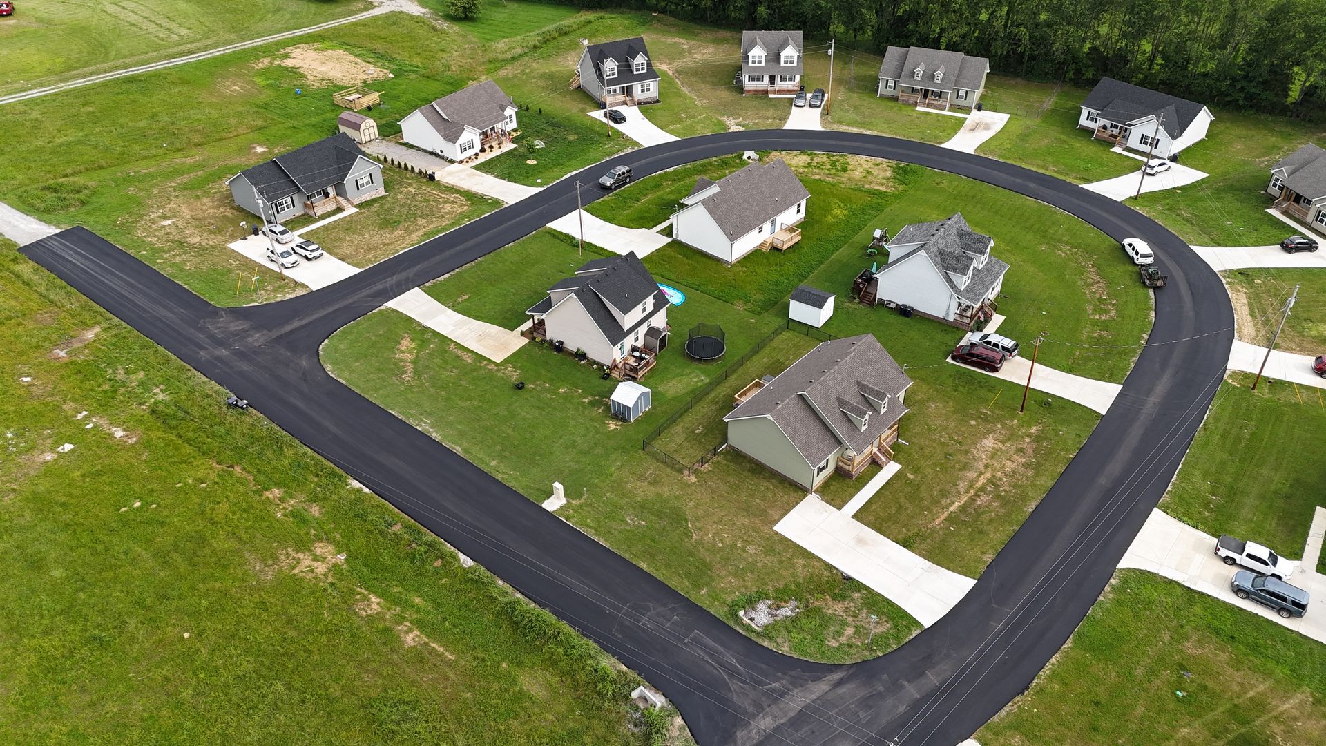 An aerial view of a residential area with houses and a road.