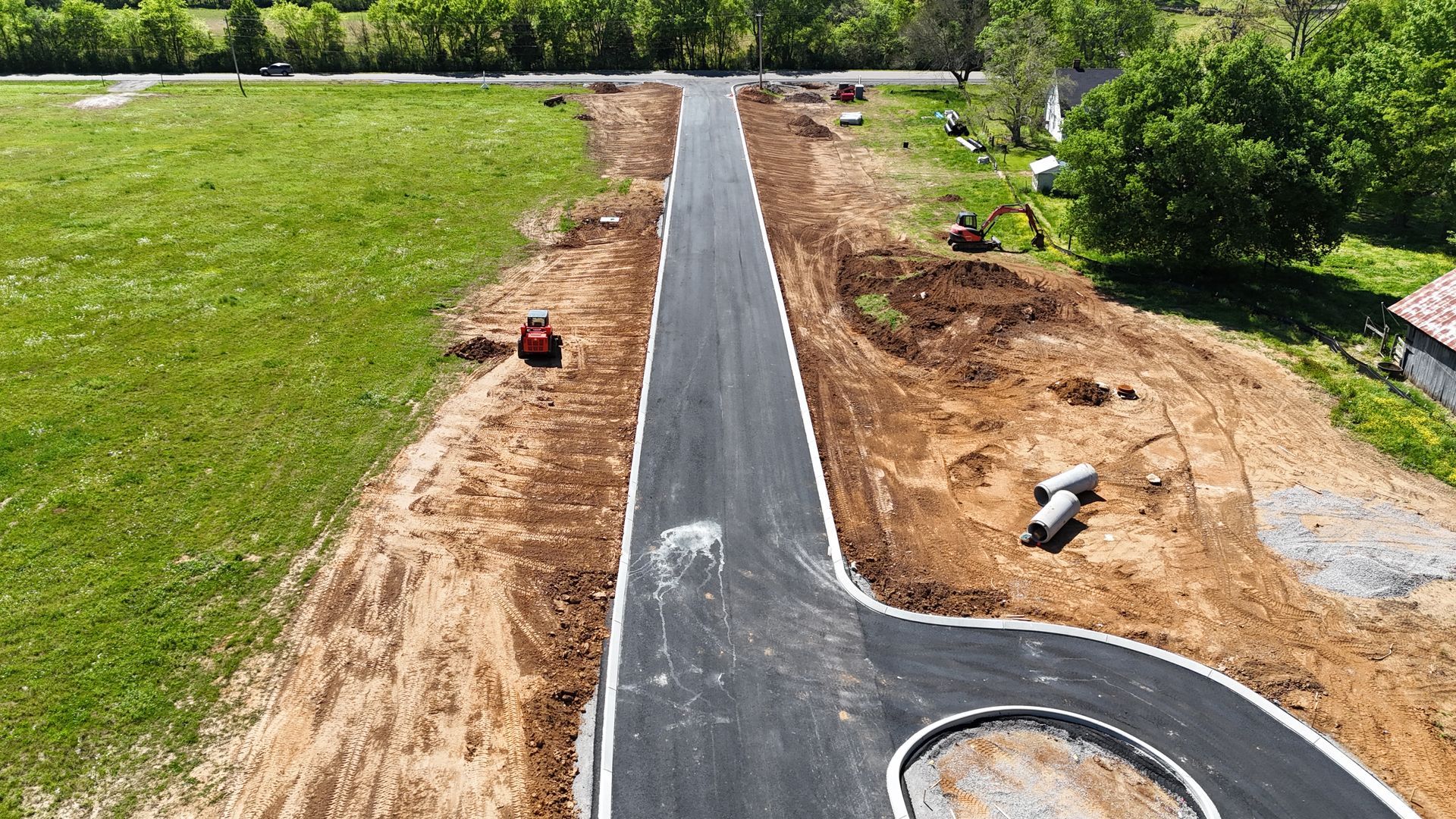 An aerial view of a road being built in a rural area.