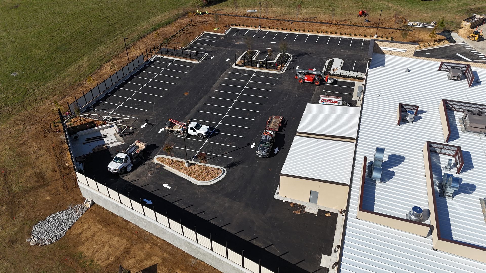 An aerial view of a building under construction with a white roof.