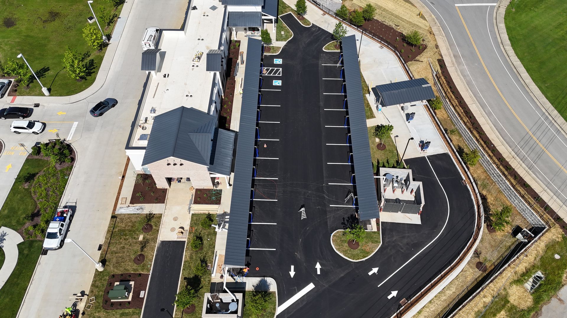An aerial view of a parking lot with a building in the background.
