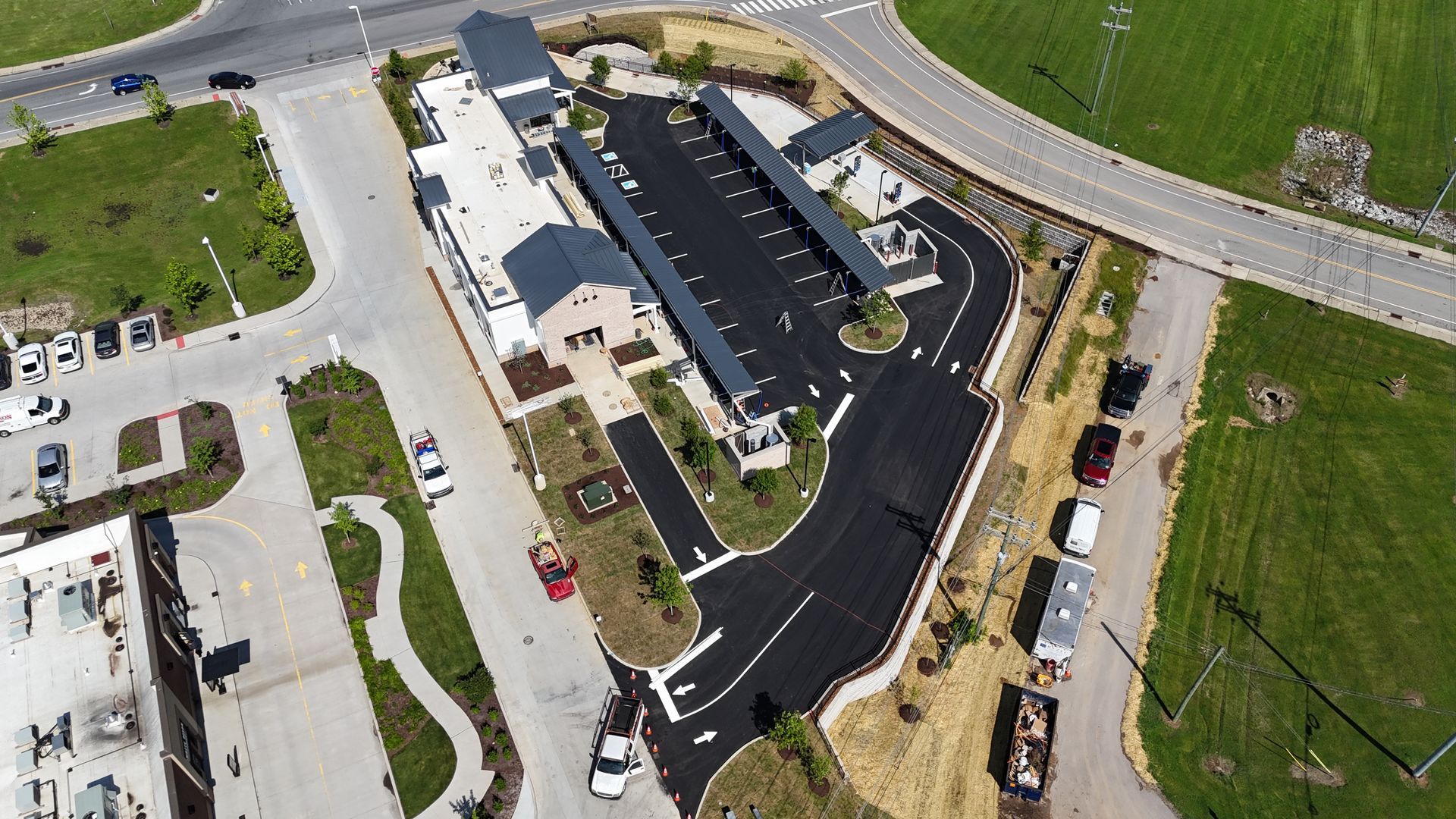 An aerial view of a parking lot with a building in the background