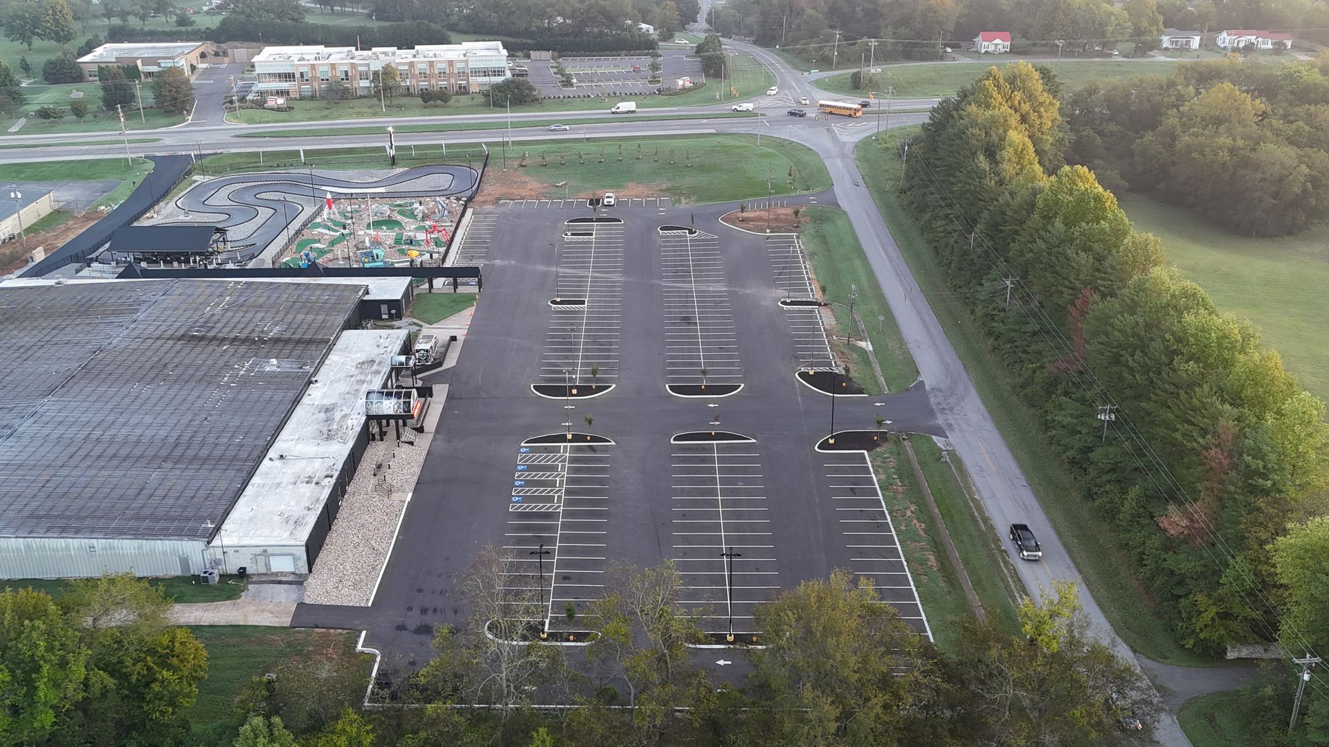 An aerial view of a parking lot with a building in the background